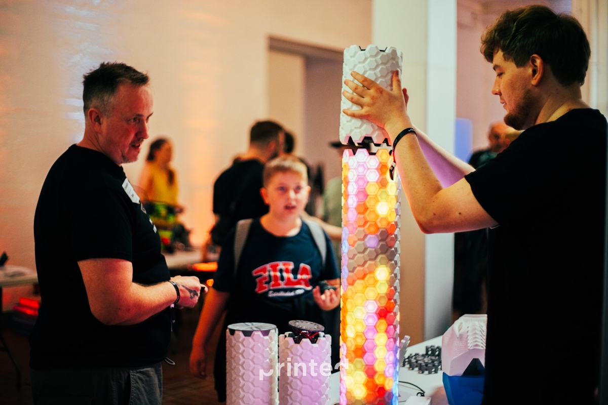 Attendees admiring a tall printed lamp